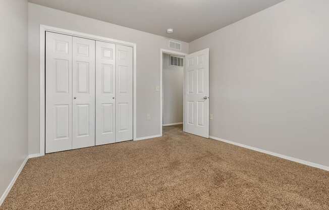 A room with white doors and a brown carpet.