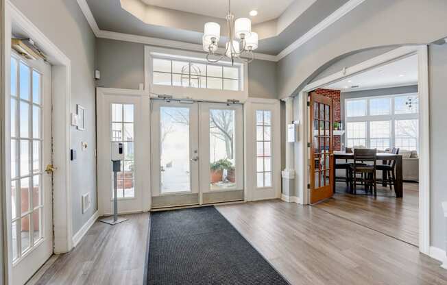 an empty living room with glass doors and a dining room table