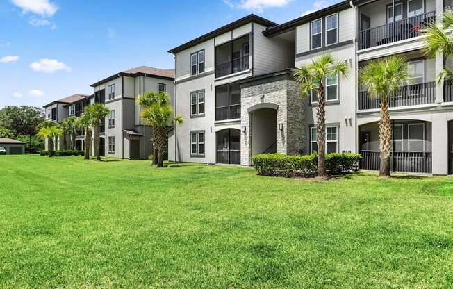 A row of apartment buildings with green lawns in front.