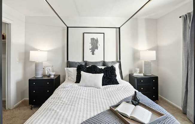 A bedroom with a bed, nightstands, and a painting on the wall.