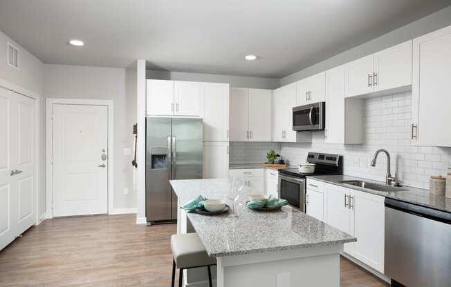 a kitchen with white cabinets and a granite counter top at 55 Fifty at Northwest Crossing, Houston