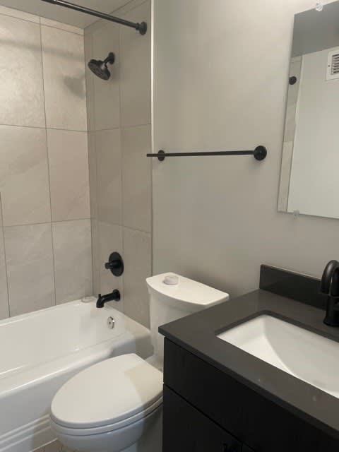 A white toilet is next to a sink in a bathroom.
