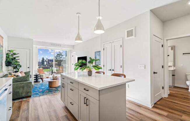 A kitchen with a large island and pendant lights.