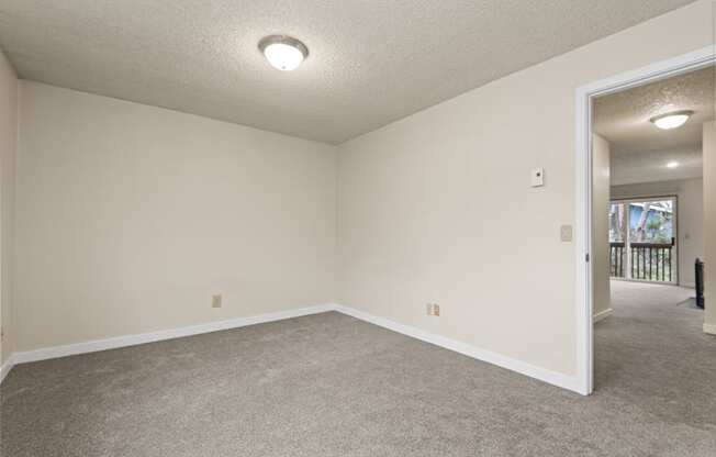 an empty living room with white walls and carpet