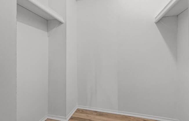 an empty room with white walls and a wooden floor