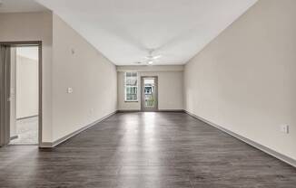 an empty living room with white walls and wood floors