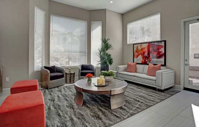 A living room with a grey sofa, a coffee table, and a red chair.