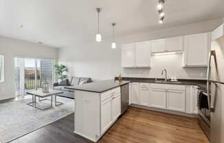 an open kitchen and living room with a couch and a table