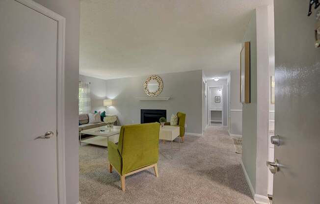 A living room with a green chair and a fireplace.