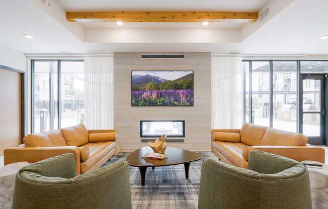 A clubroom with a TV lounge, two-way fireplace, and lounge seating.