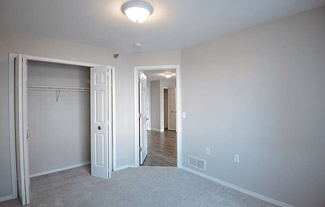 a bedroom with a closet and a closet door open