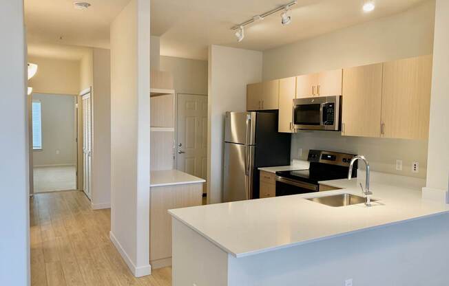 A kitchen with white countertops and stainless steel appliances at Wilsonville Summit Apartments, Oregon, 97070