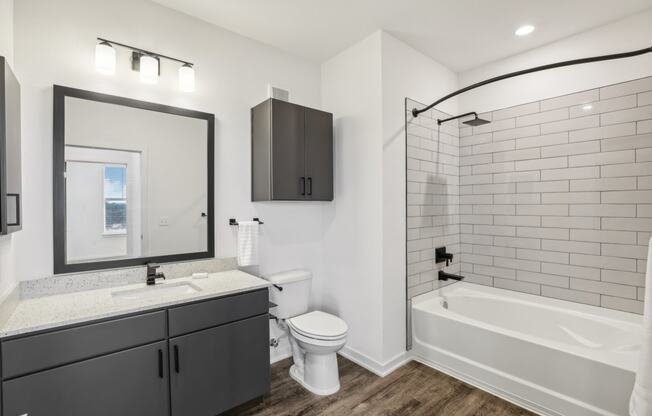 a white bathroom with a large mirror and a white tub and sink at Drift, Daytona Beach, FL, 32117