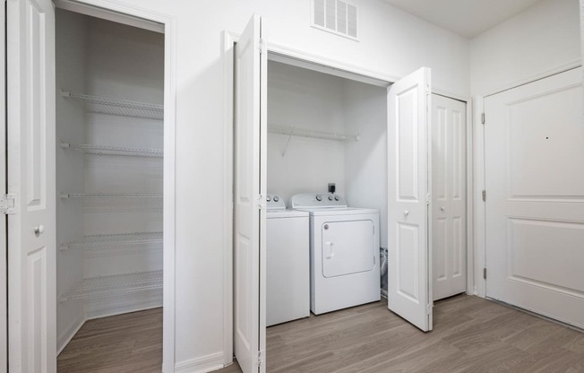 a bedroom with a washer and dryer and a closet with white doors