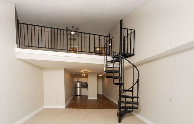 the loft in the great room of a house with a spiral staircase