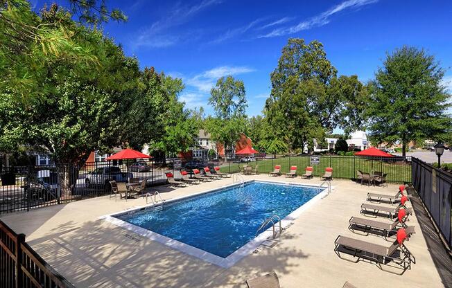 a swimming pool with chaise lounge chairs and umbrellas