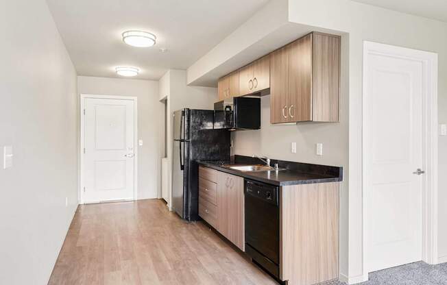 A kitchen with black appliances and wooden cabinets.