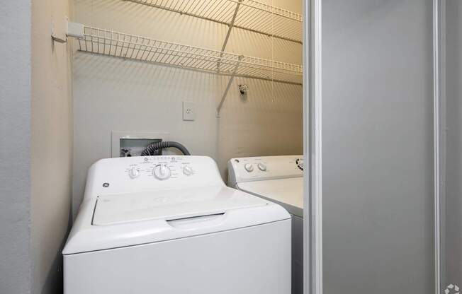 A white washing machine in a small laundry room.