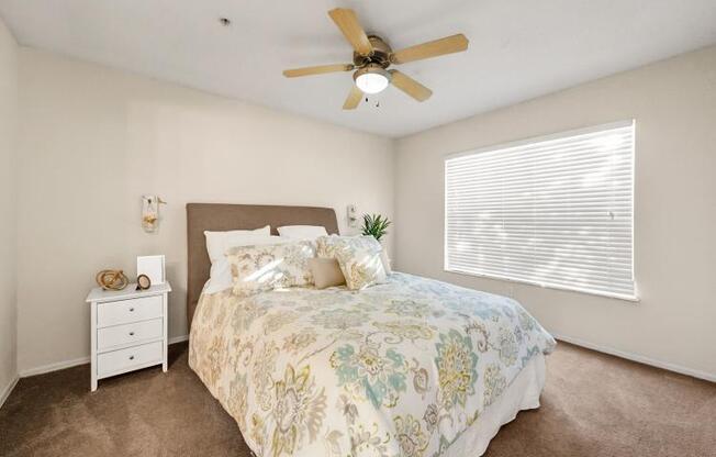 a bedroom with a bed and a ceiling fan