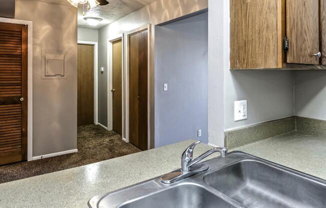 a kitchen with a sink and a hallway with closets