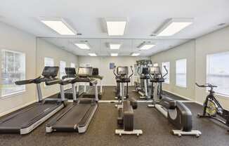 a gym with treadmills and exercise bikes on the floor