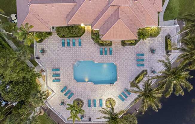 a pool is circled by chairs and palm trees
