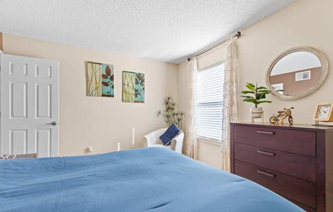 a bedroom with a bed and a dresser and a window