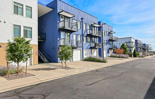 A blue apartment building with a tree in front of it.