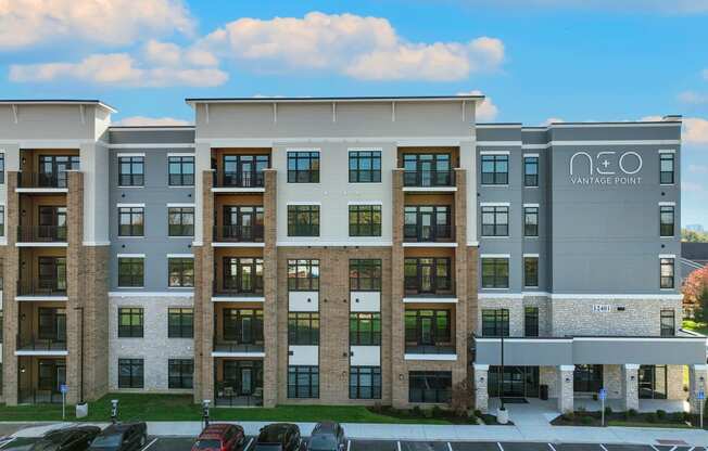 a large apartment building with cars parked in a parking lot