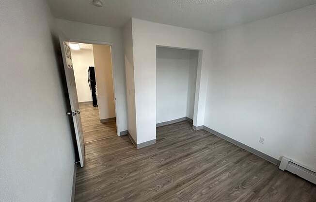 a bedroom and hallway with white walls and wood flooring at Kings Court, Anchorage, AK 99501 ? 