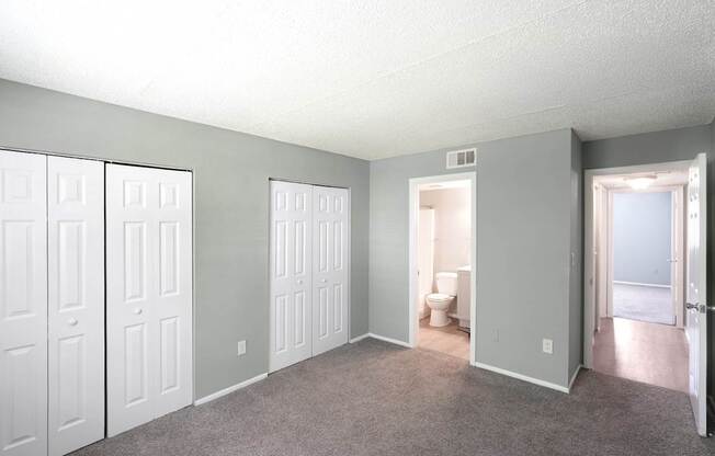 A room with white doors and a carpeted floor.