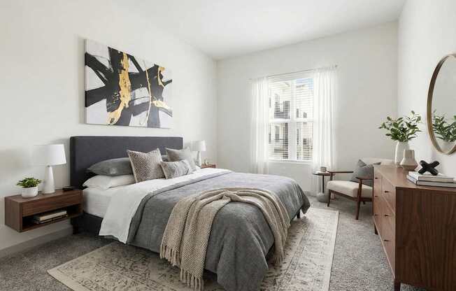 A bedroom with a large bed and a painting on the wall.