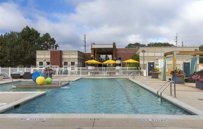 a swimming pool with a building in the background at Village Club of Rochester Hills, Shelby Township, MI