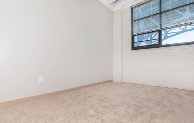 an empty living room with white walls and a window