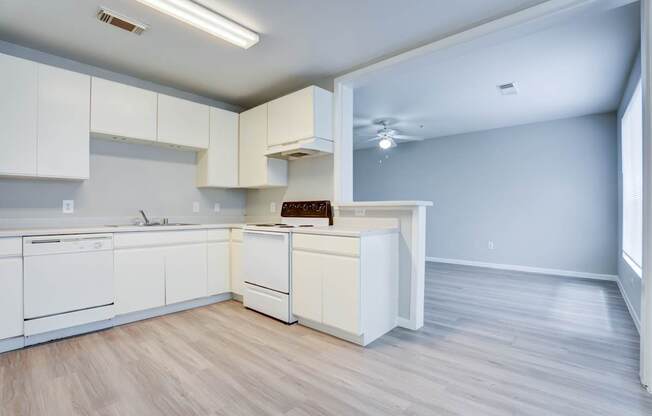 A kitchen with white cabinets and appliances.