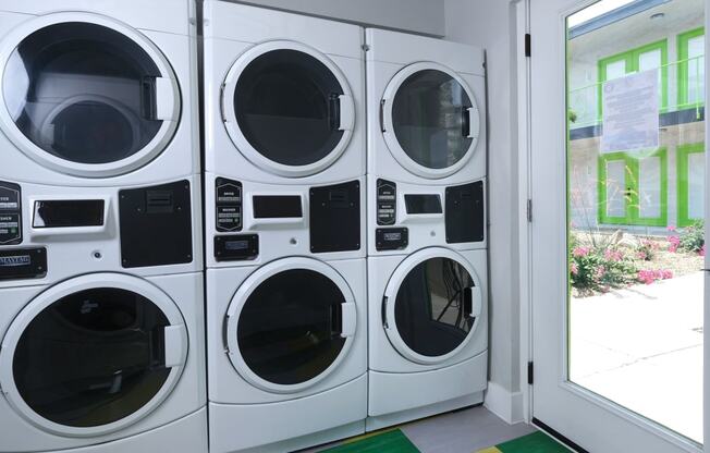 Pet Friendly Apartments in Las Vegas, NV - Bright Community Laundry Room with Multiple Front Load Machines and Large Windowed Doors