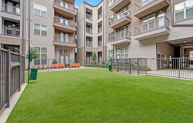 A large grassy area in front of apartment buildings.