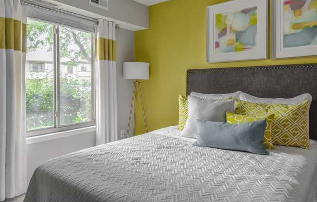 a bedroom with yellow walls and a bed with pillows