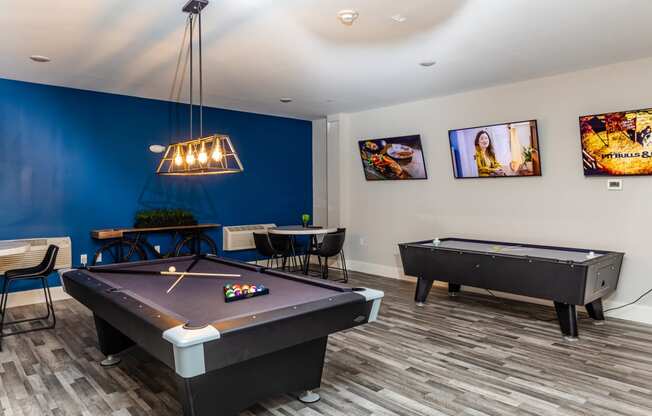 a game room with two pool tables and a ping pong table