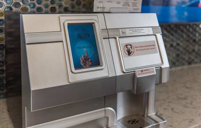 an atm machine with a screen showing a hand pressing a button at The Whitworth, Williamsburg, 23185