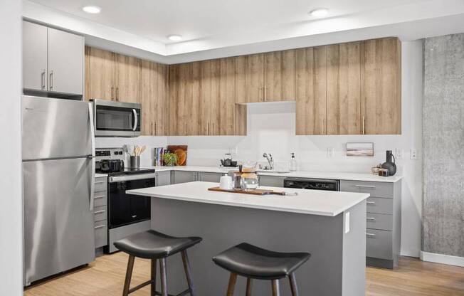 A modern kitchen with a large island and stools. at Riverfront Everett, Washington, 98201