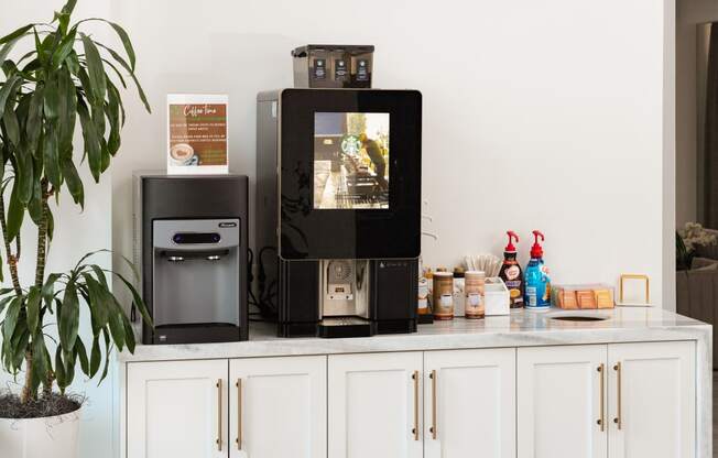 a white kitchen with a coffee machine and a television