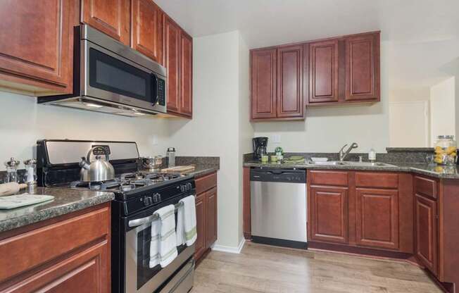 A kitchen with dark wood cabinets and a black stove top.