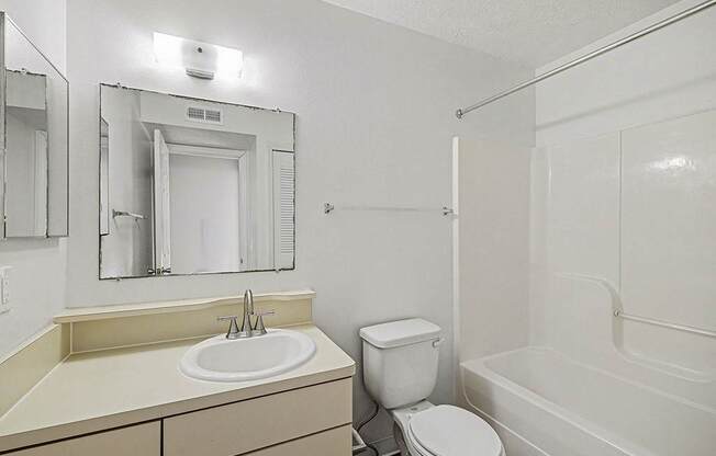 A white bathroom with a sink, toilet, and bathtub.