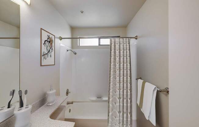 A bathroom with a white tub and a shower curtain.