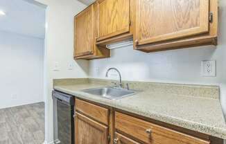 A kitchen with wooden cabinets and a granite countertop.