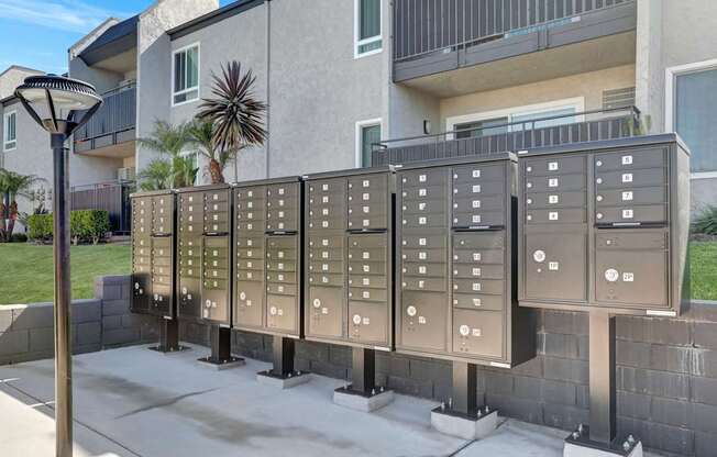A row of mailboxes are lined up on a sidewalk.