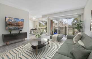 A living room with a grey couch and a painting on the wall.