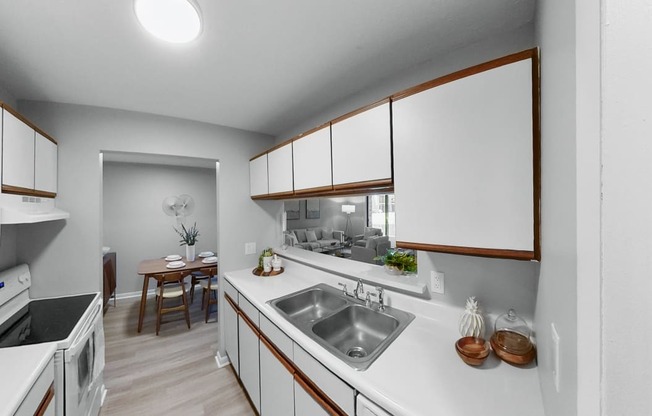 a kitchen with white counter tops and a stainless steel sink