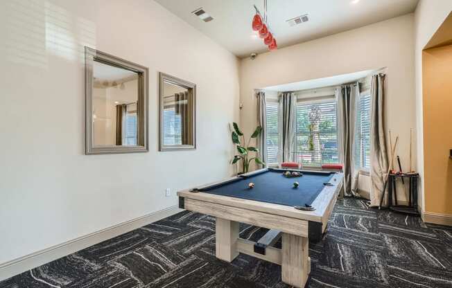 clubhouse with billiard table and large windows letting in natural light